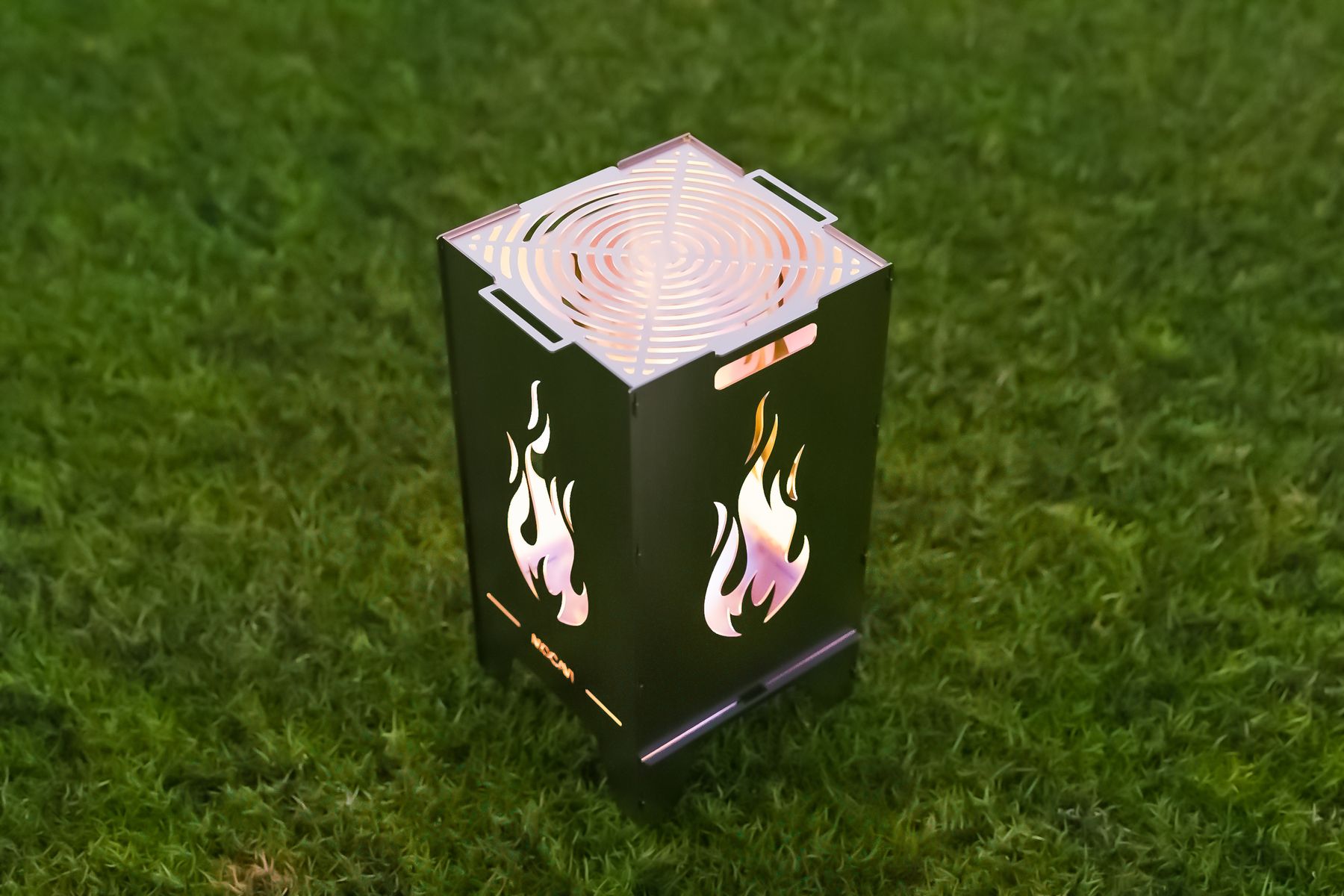 MOCAVI Fire, Feuertonne mit Grillrost, zeigt die Flame Feuertonne auf Rasen im Garten.