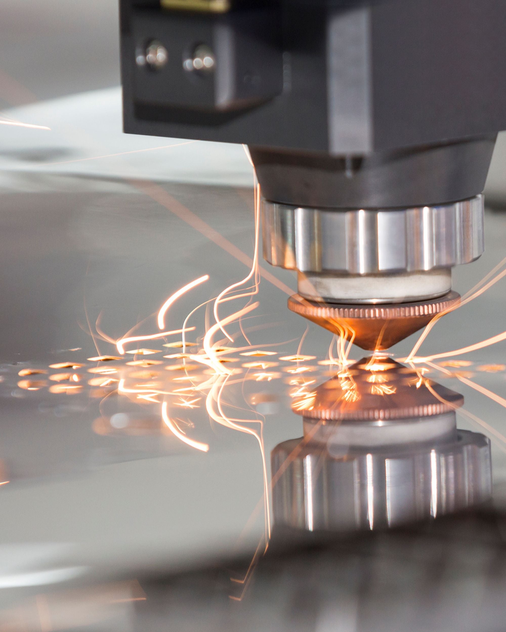 Laserstrahl beim Auslasern eines MOCAVI Motivs aus Metall für die Feuertonne