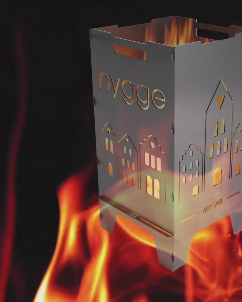 Video laden: Video ohne Ton mit rot lodernder Flamme im Hintergrund, im Vordergrund eine personalisierte Feuertonne mit Skandi Häusern und Hygge Motiv.