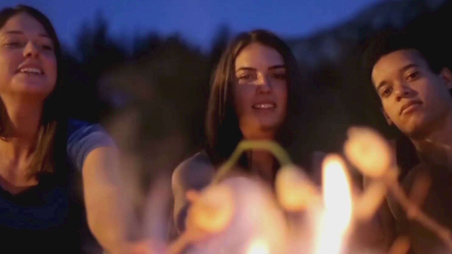 Video laden: Drei Freunde rösten Marshmallows am Lagerfeuer in fröhlicher Stimmung, kein Ton.

